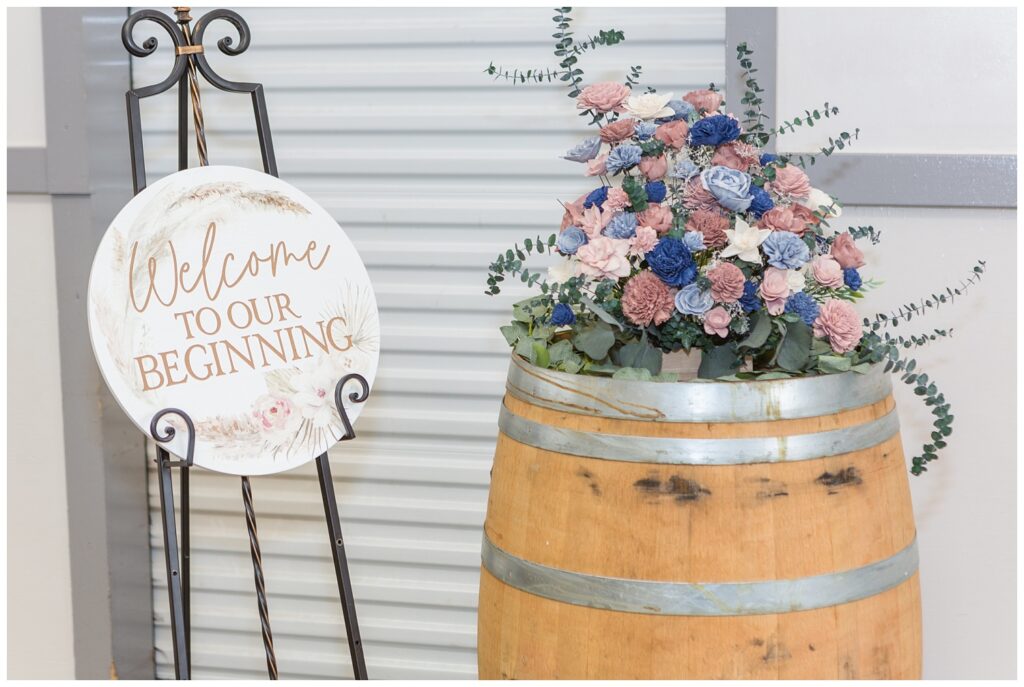 reception sign and flowers sitting on a barrel at Woods County Fairgrounds