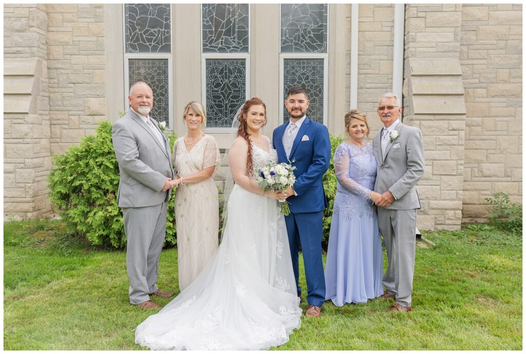 bride and groom posing with both sets of parents after ceremony in Ohio