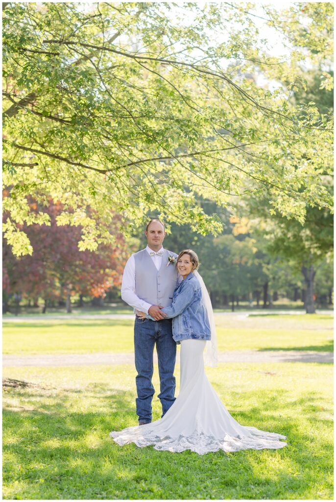 bride and groom standing under a large tree in Huron County Ohio