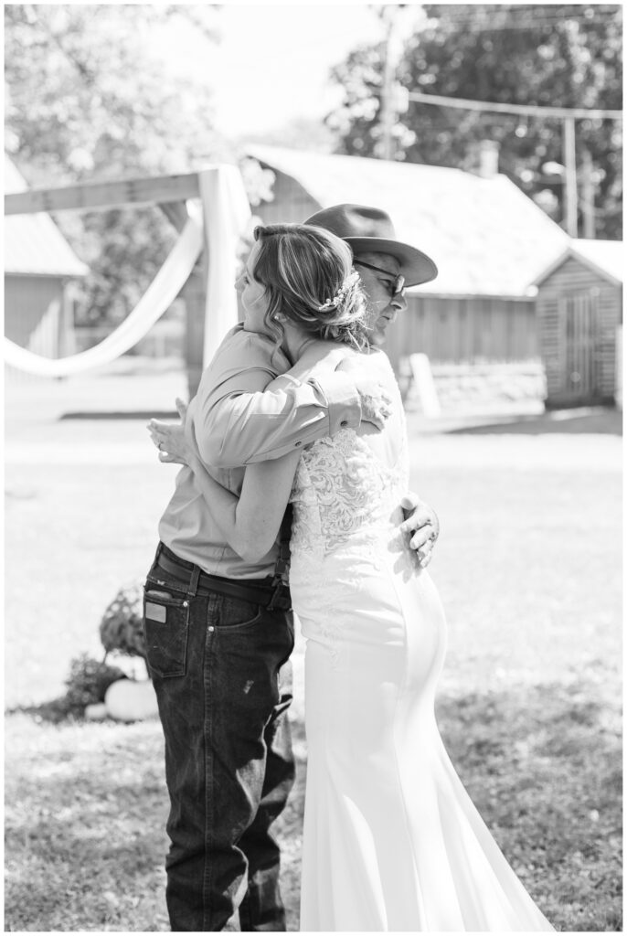 bride hugging her dad during a first look at the Huron County Fairgrounds