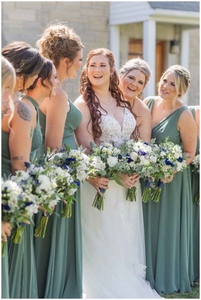 bride laughing with her bridesmaids outside the church in Bellevue, Ohio