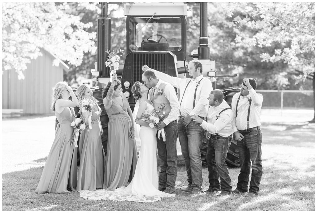 wedding party posing in front of a large green tractor at Huron County Fairgrounds