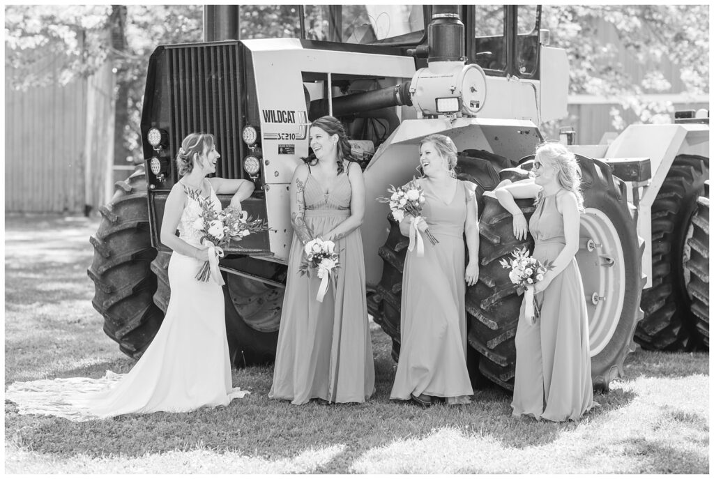 bridal party laughing in front of a large green tractor at Norwalk, Ohio wedding