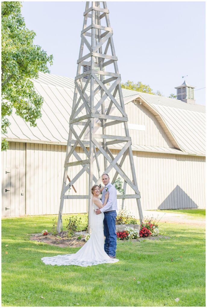 bride and groom posing in front of a tall windmill in Norwalk, Ohio