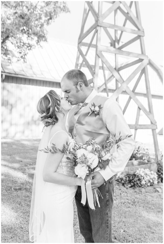 bride and groom posing in front of a tall windmill in Huron County Ohio
