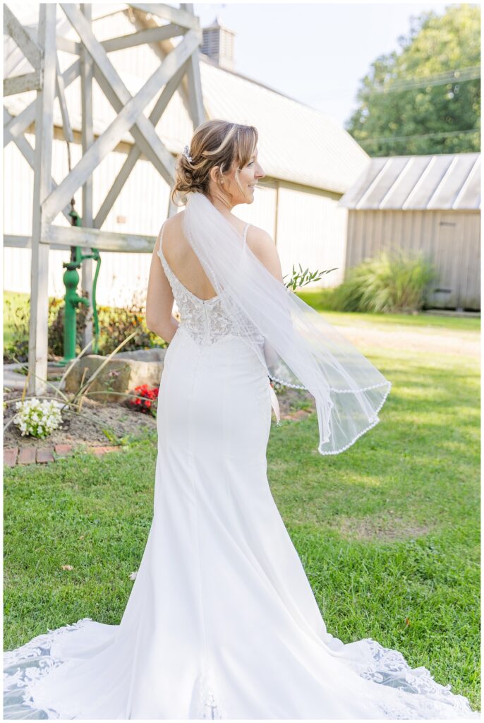 bride showing the back of her dress and veil in front of a windmill in northwest Ohio