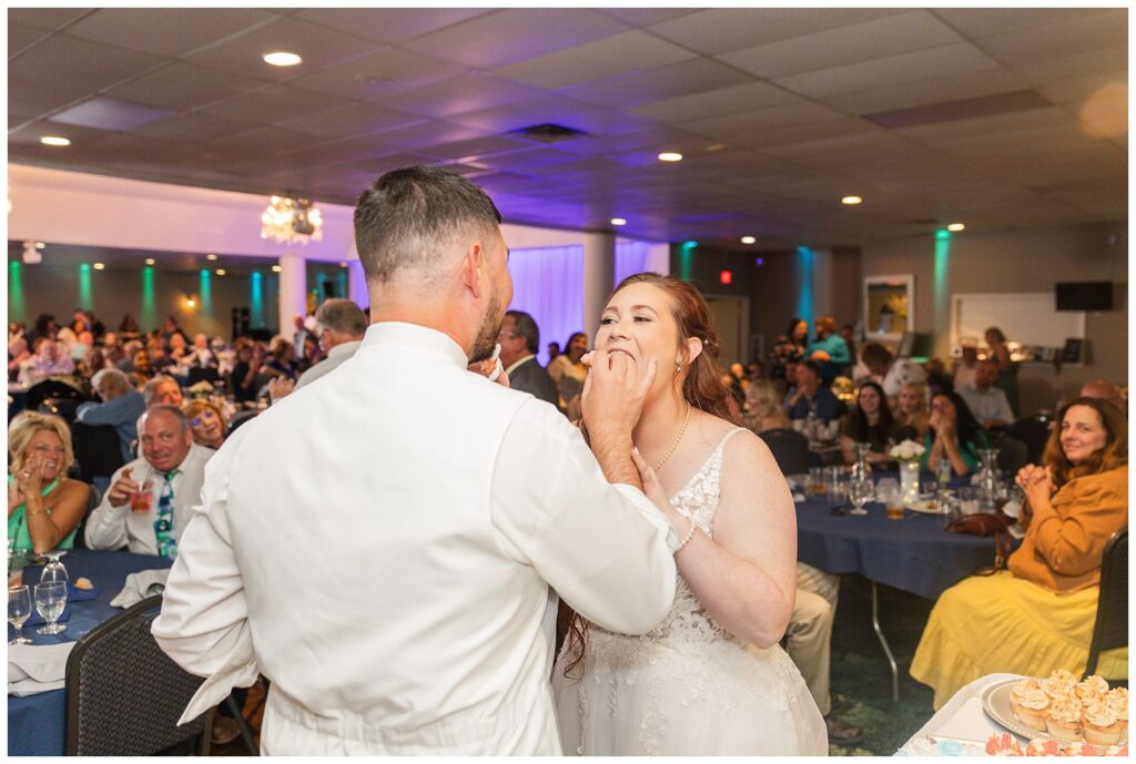 bride and groom feed each other cake at wedding reception in northwest Ohio