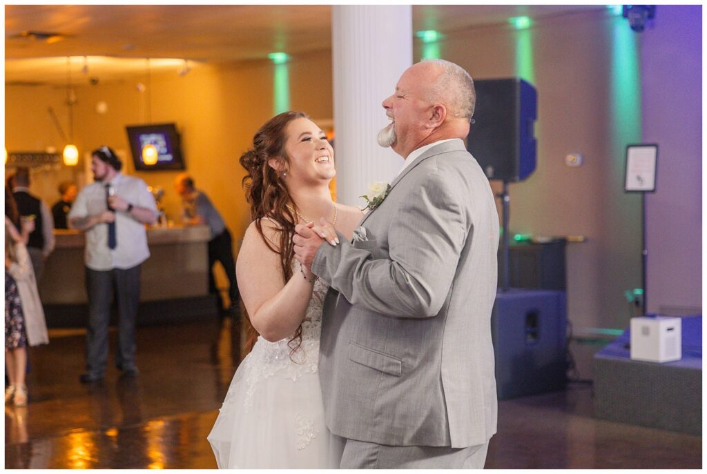 bride and her dad laughing while having dance together at wedding reception