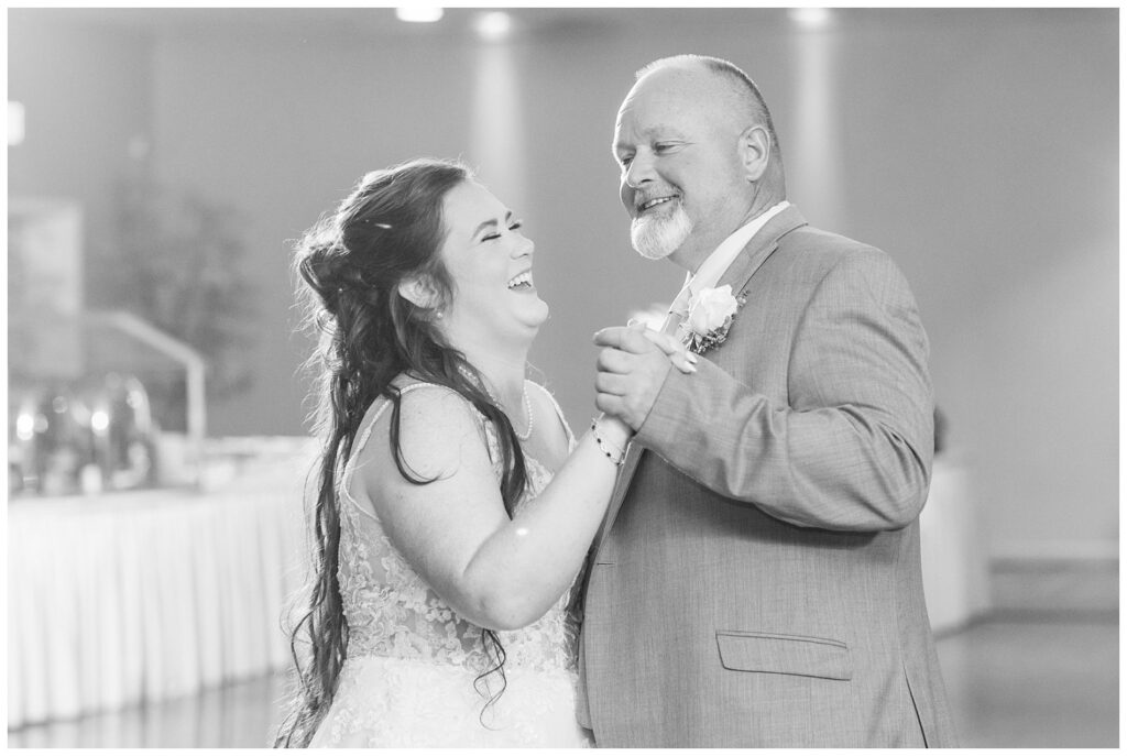 bride and her dad laughing while having dance together at wedding reception