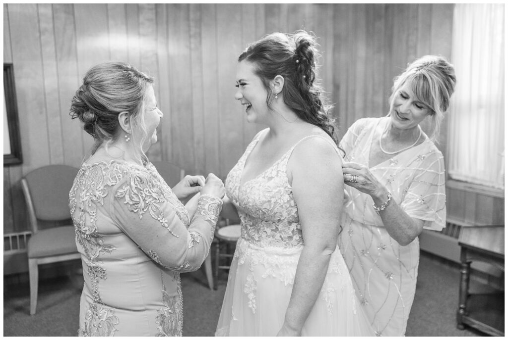 bride's mom and groom's mom helping her get ready at church in Bellevue, Ohio