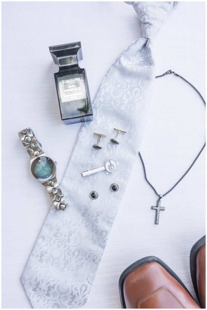 groom's details including a tie, cufflinks, watch and necklace