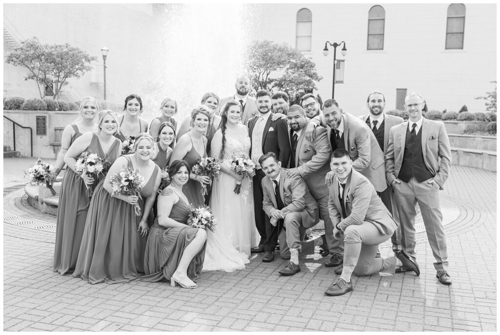 full wedding party posing together in front of the fountain in Sandusky, Ohio