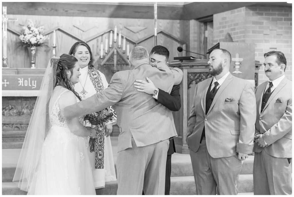 groom hugging the bride's dad at the beginning on the wedding ceremony in Bellevue, Ohio