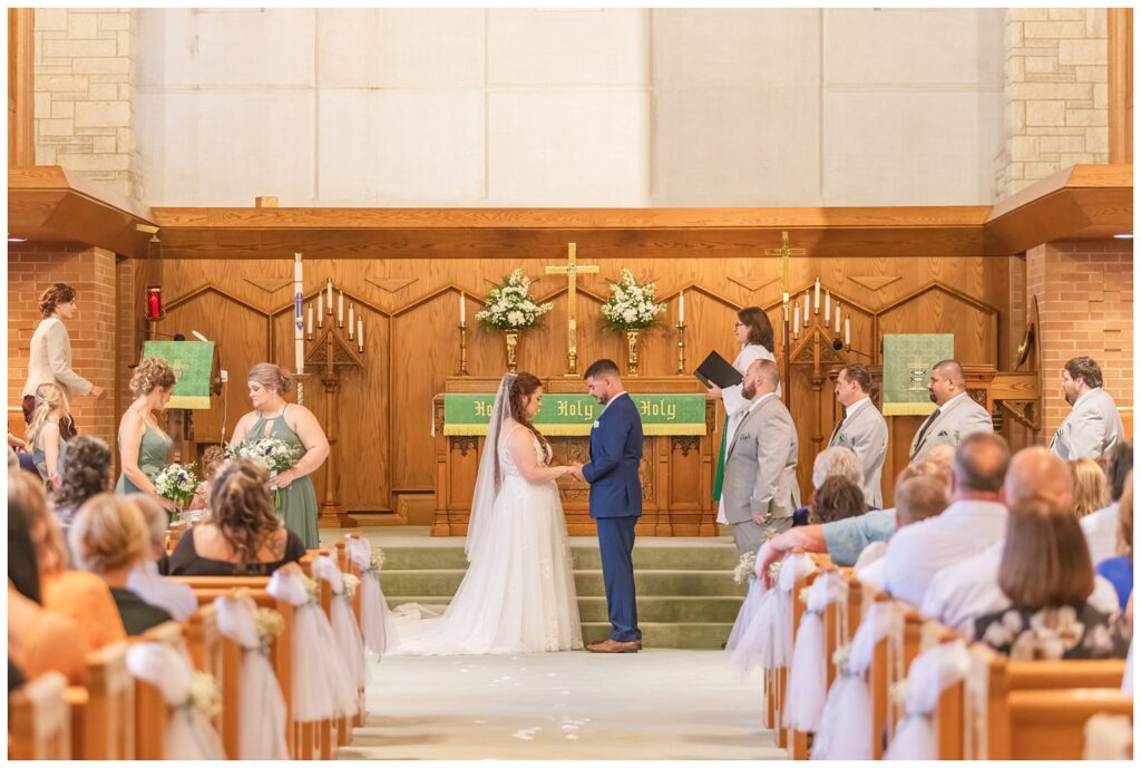 bride and groom holding hands during fall wedding ceremony in northwest Ohio