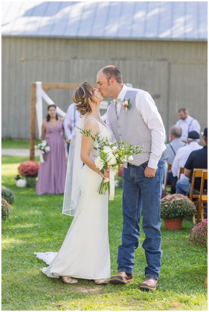 bride and groom share kiss at end of wedding ceremony in Huron County Ohio