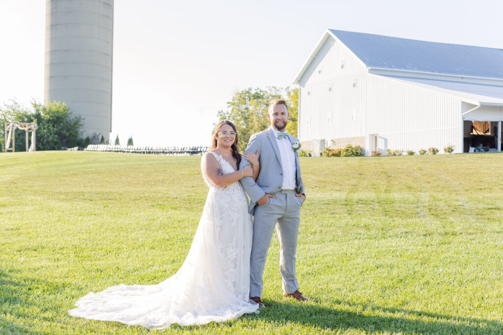 wedding couple standing in front of a white barn and silo in Tiffiin, Ohio
