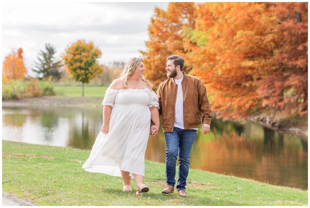 fall engagement session near a lake and orange trees in Ohio