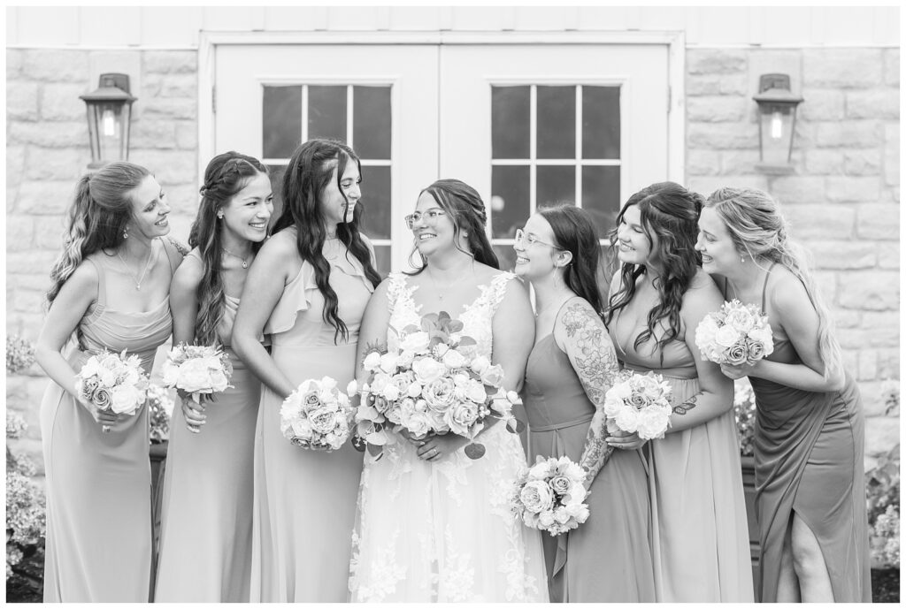 bridal party smiling in front of wedding venue's white doors in Tiffin Ohio