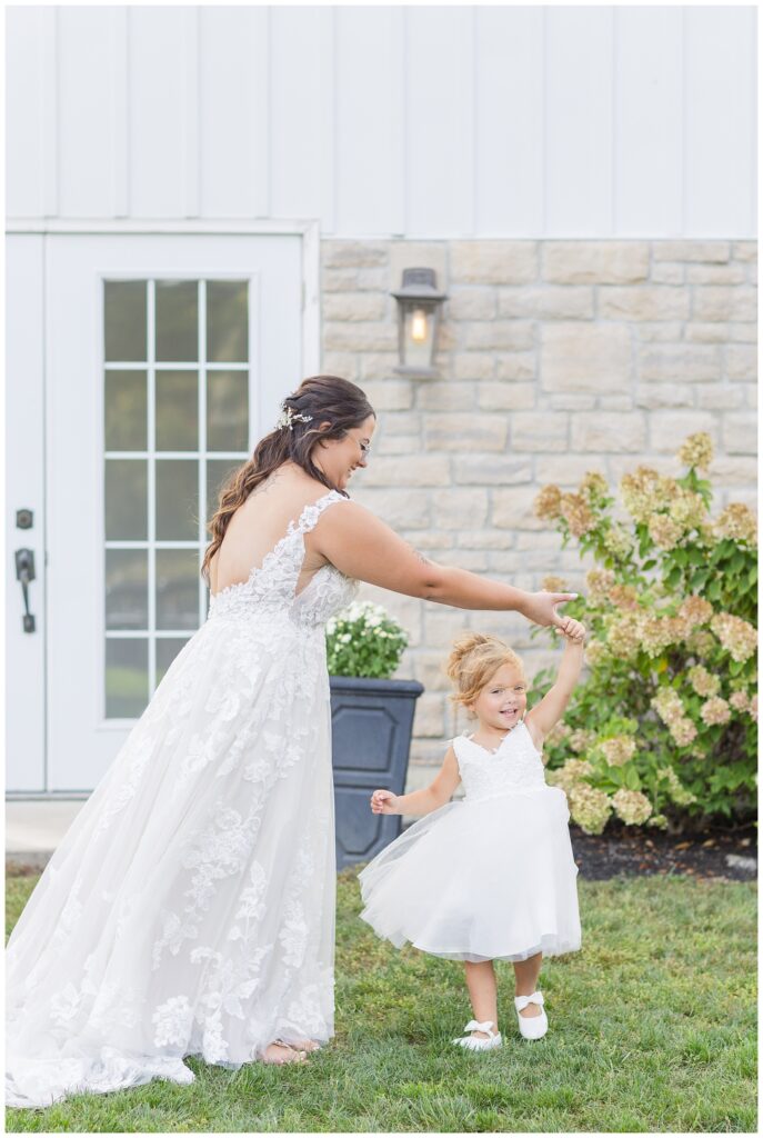 bride twirling her daughter outside before the wedding ceremony