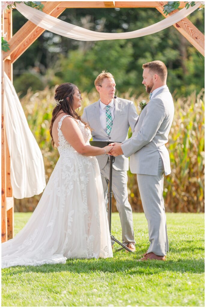couple exchanging vows during outdoor wedding ceremony at Tiffin Ohio venue