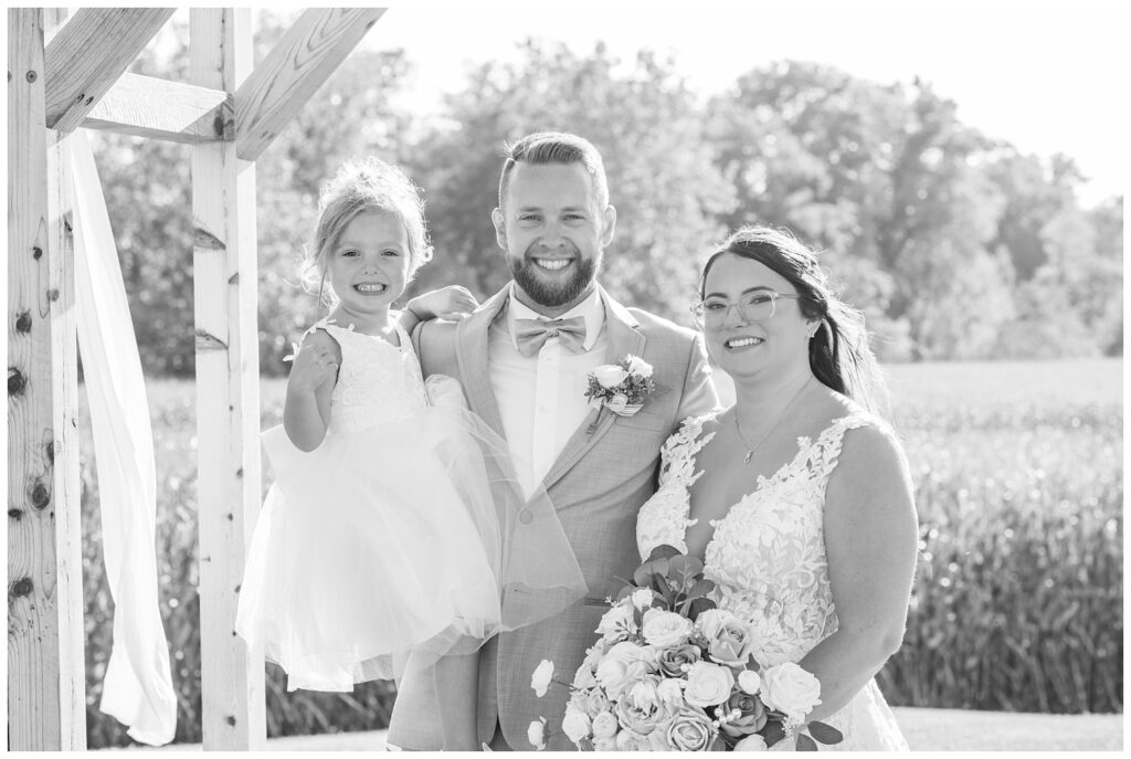 bride and groom holding their daughter after wedding ceremony in Tiffin Ohio