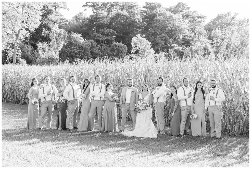full wedding party posing in front of the  corn field at Arlington Acres
