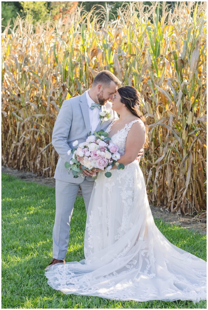 bride and groom posing in front of the corn field at Arlington Acres