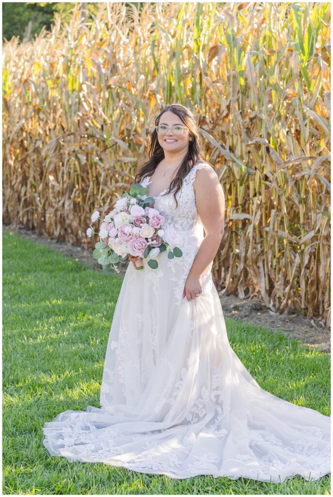 bride standing with bouquet in front of a corn field in Tiffin Ohio