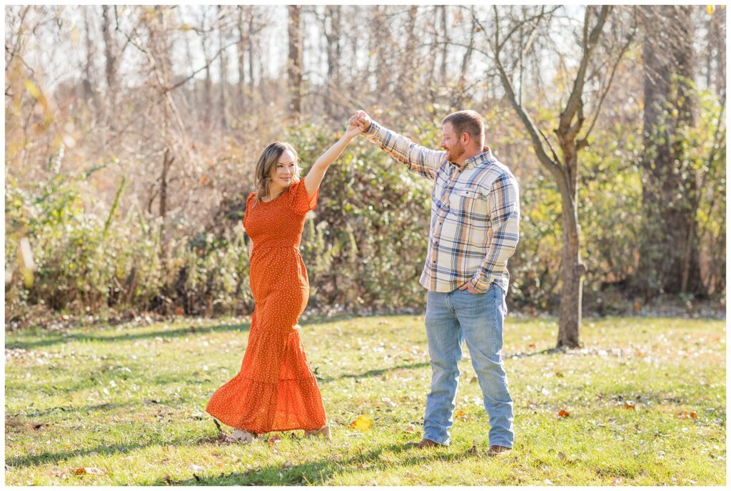 man twirling his fiancé at Bradner Preserve in Ohio for engagement session