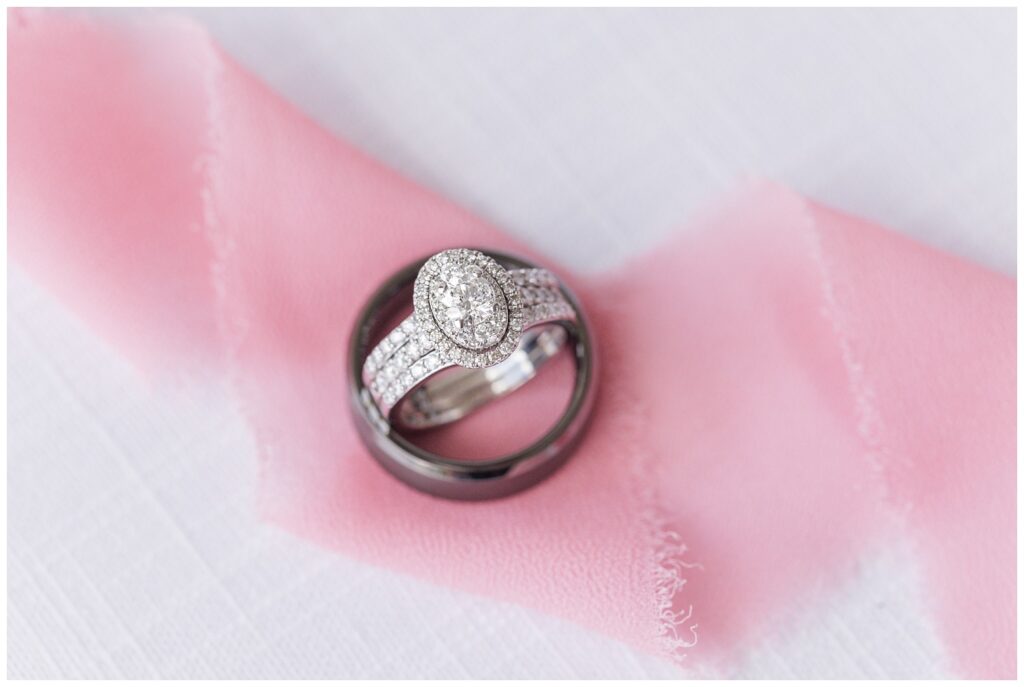 bride and groom's wedding rings sitting on top of pink ribbon 