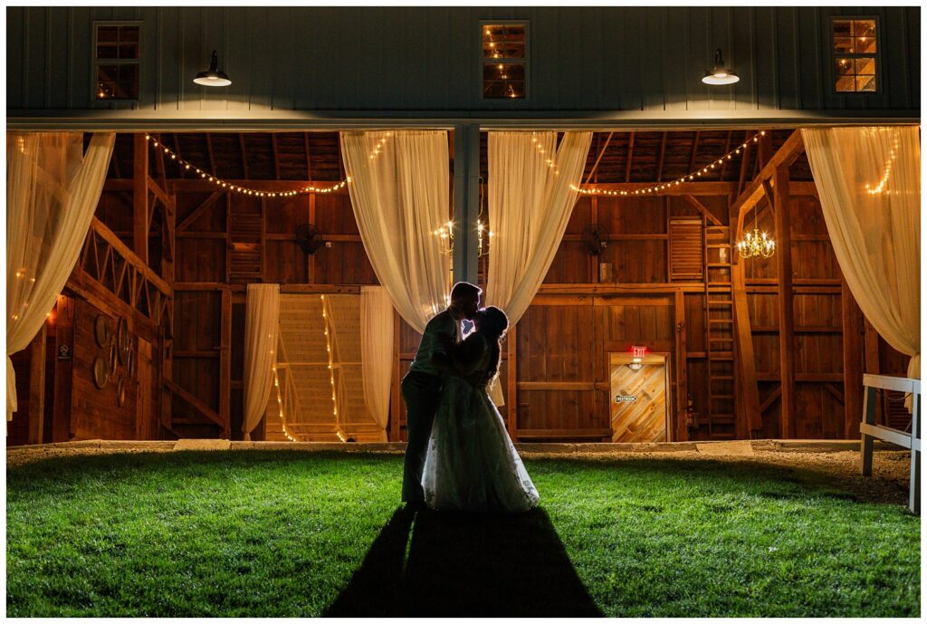 groom kissing bride outside the wooden barn in Tiffin Ohio
