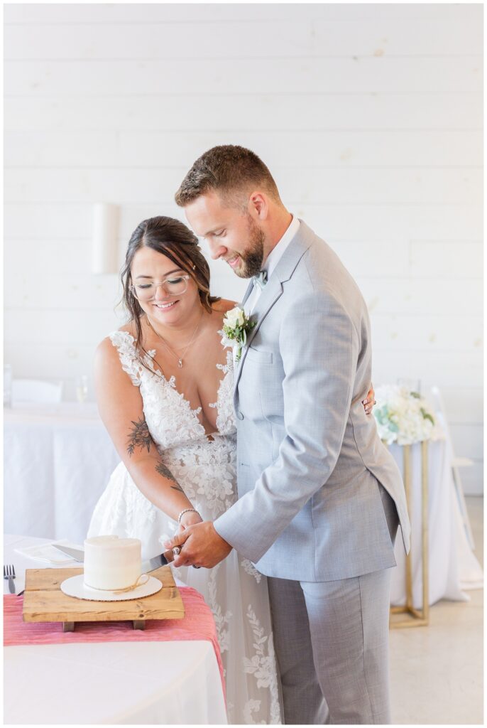 groom and bride cut their cake at Arlington Acres venue