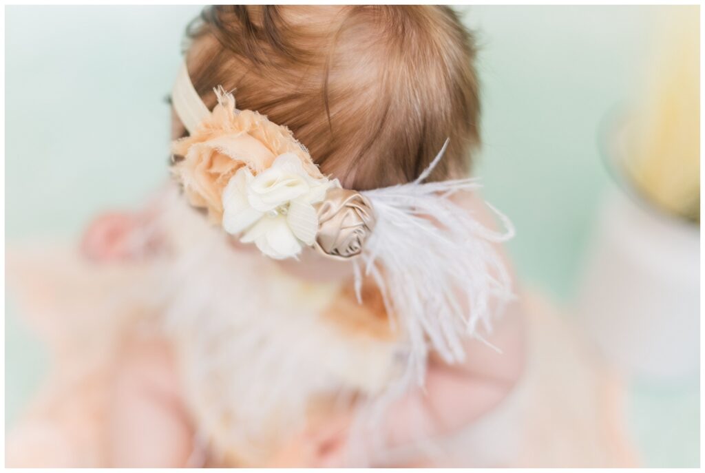 detail of baby's feather and floral headband at child portrait session