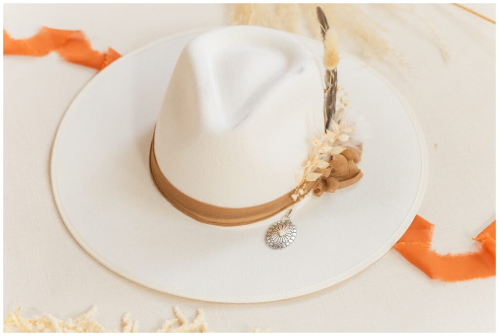 white cowboy hat sitting on top of orange ribbon at Tiffin, Ohio wedding