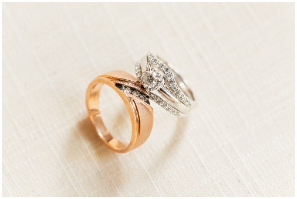 two wedding rings leaning against each other on an ivory flat lay mat