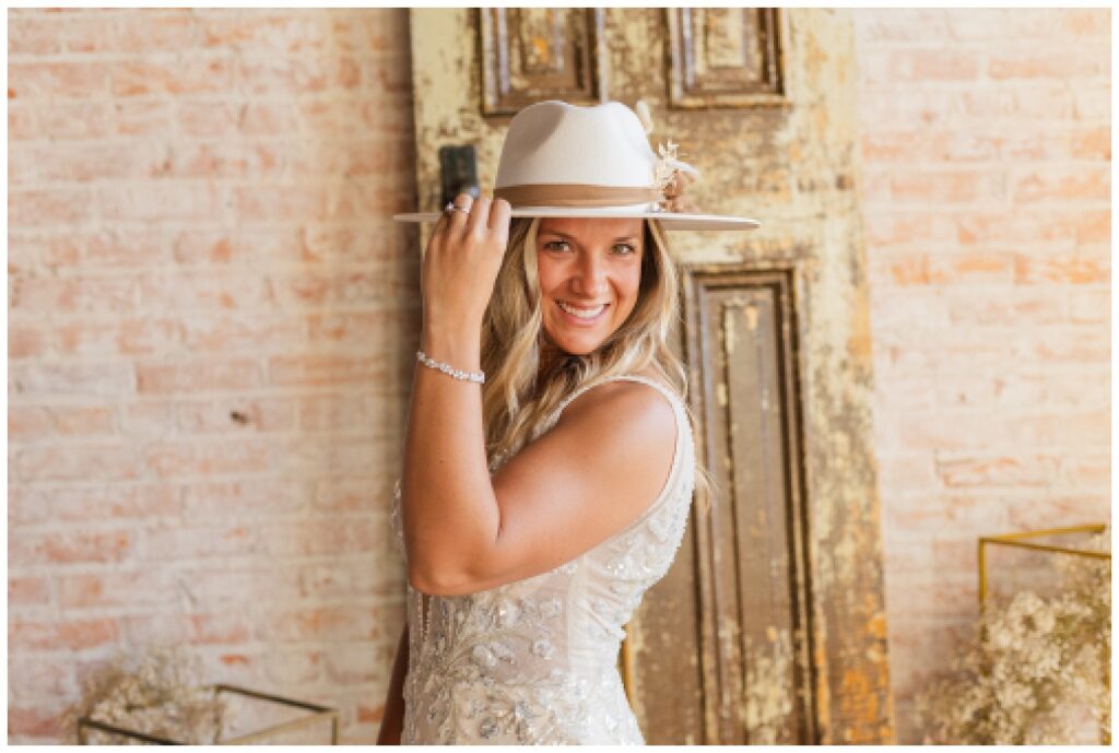 bride wearing an ivory and brown cowboy hat while smiling at Green Springs, Ohio wedding