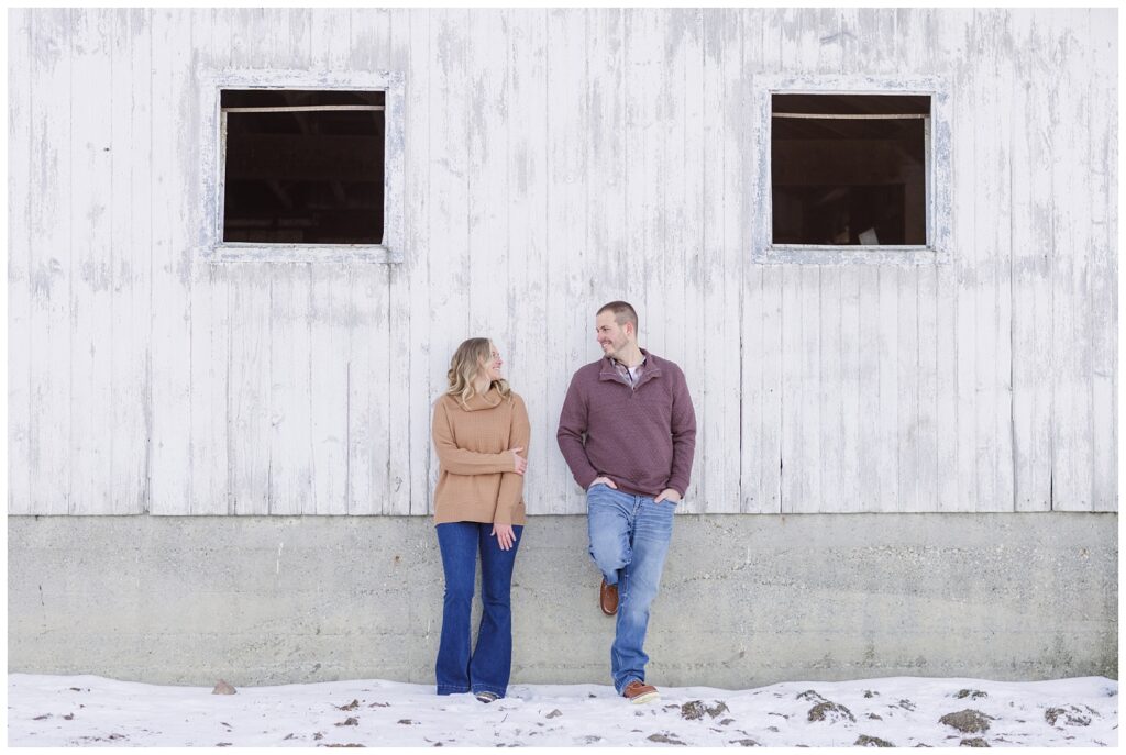 couple leaning against the outside of a white barn in northwest Ohio