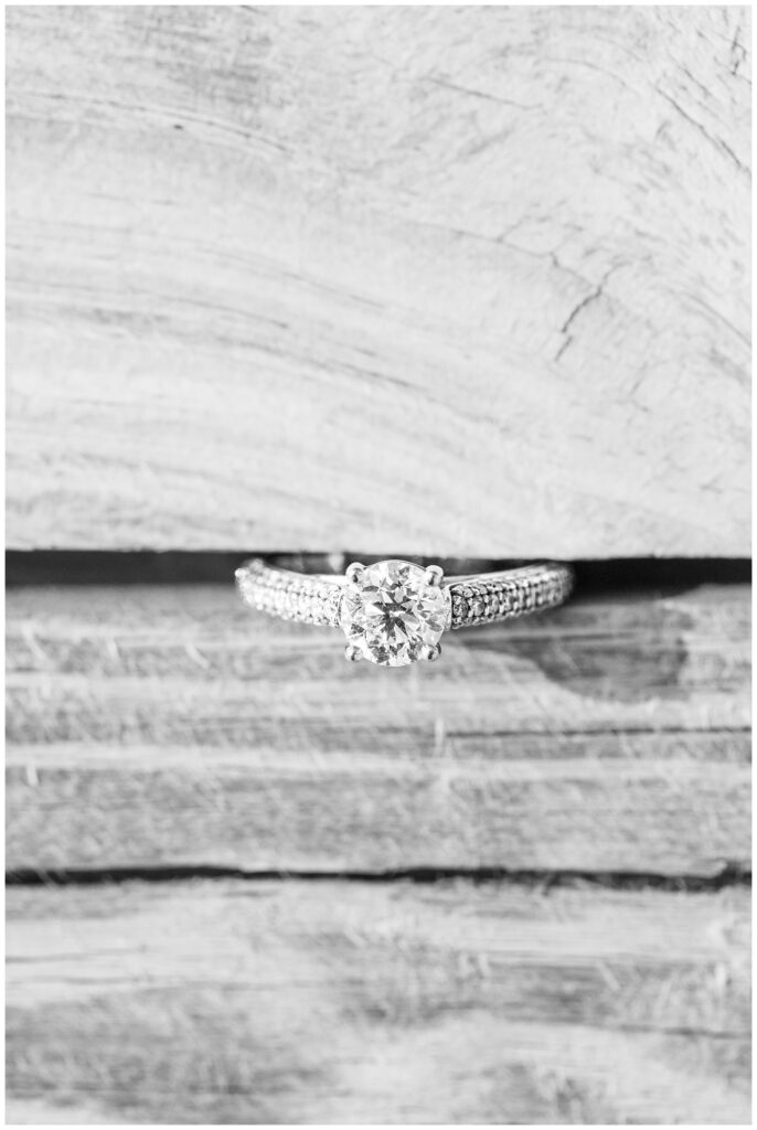 engagement ring sticking in between wood floorboards in a barn