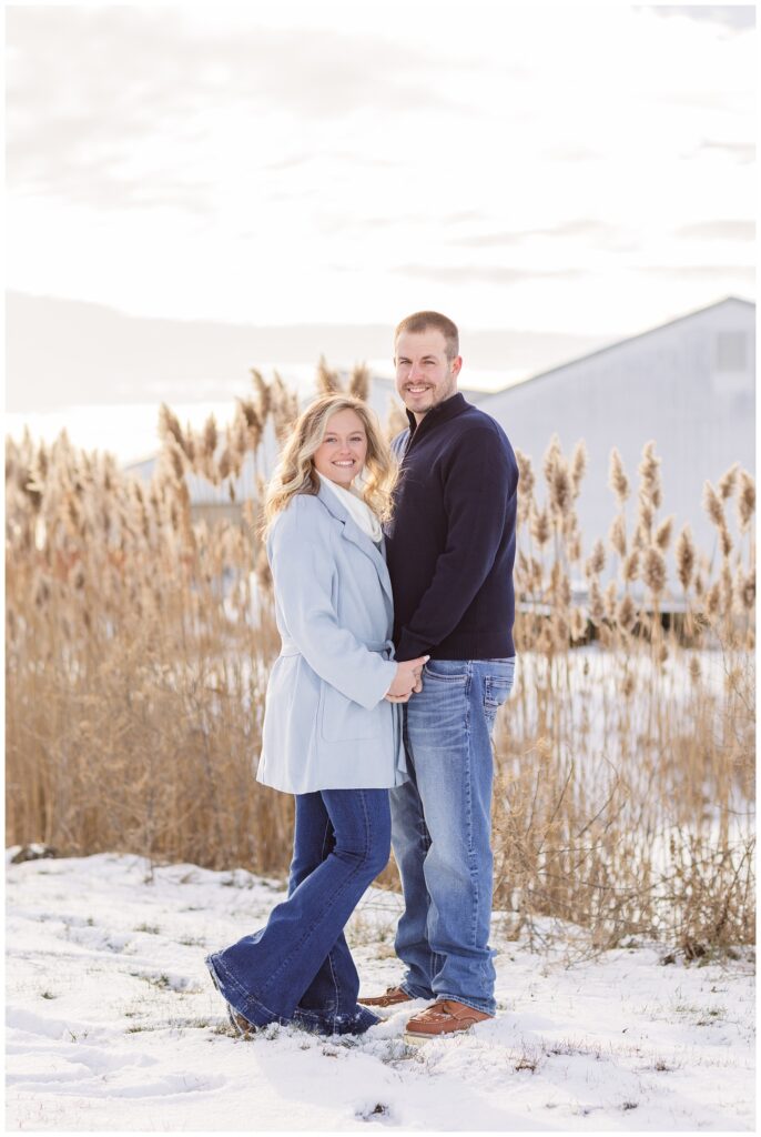 couple posing in the snow among tall grass on a farm in Fremont, Ohio