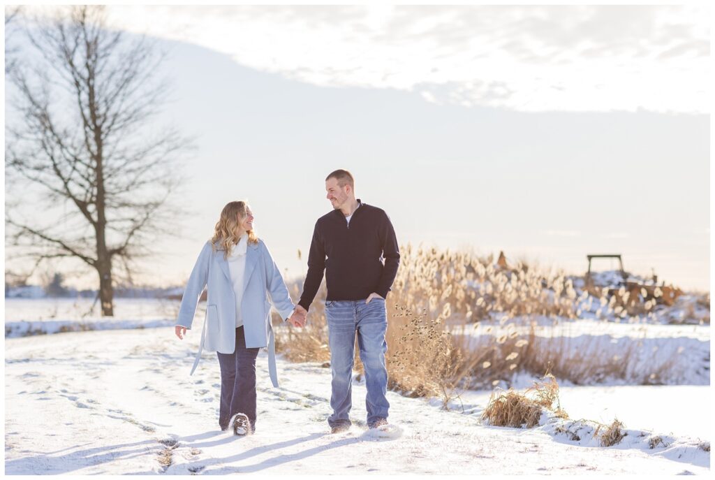 couple walking through the snow for a winter engagement session in Fremont, Ohio