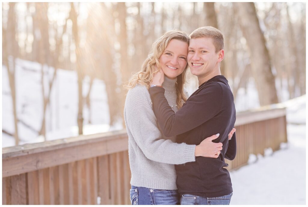 engaged couple hugging on a snow covered bridge in Lewis Center, Ohio
