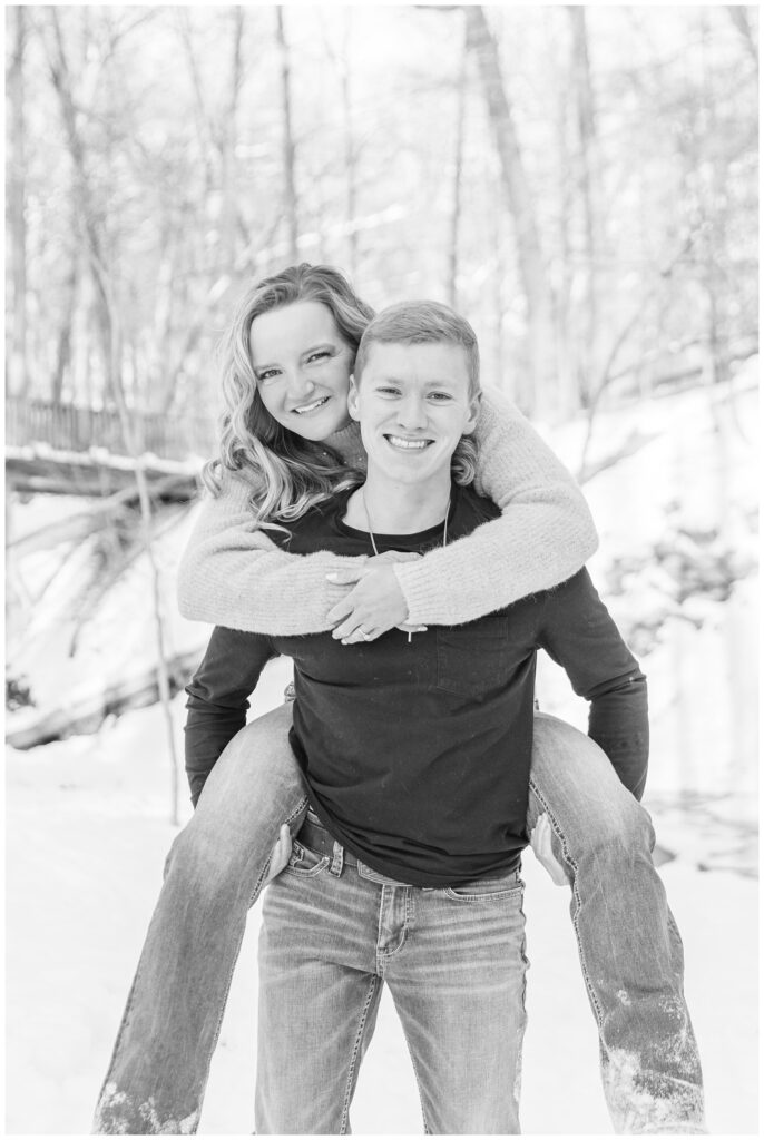 engaged couple piggybacking in the park in Lewis Center, Ohio in the snow