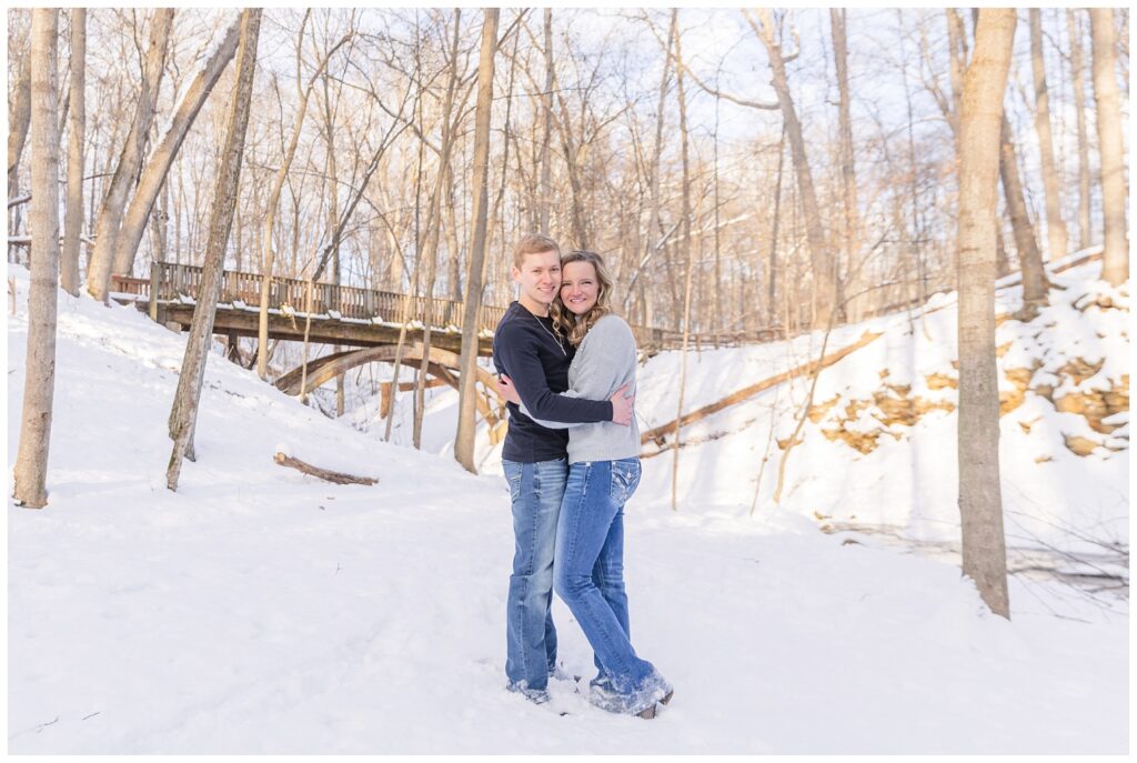 couple hugging while standing in the snow for winter engagement in Columbus, Ohio