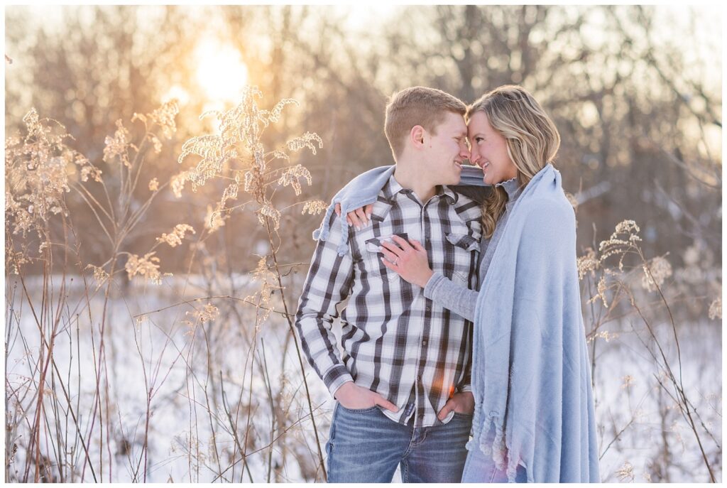 engaged couple wrapped in a blue blanket at portrait session in Lewis Center, Ohio