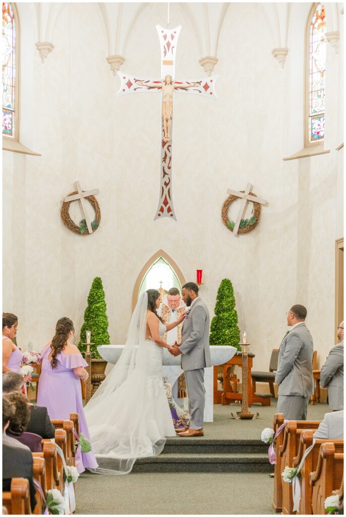 couple holding hands at the altar at a church wedding in March