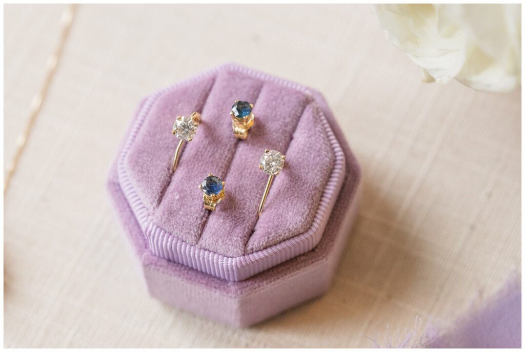 bride's wedding earrings sitting in a purple ring box
