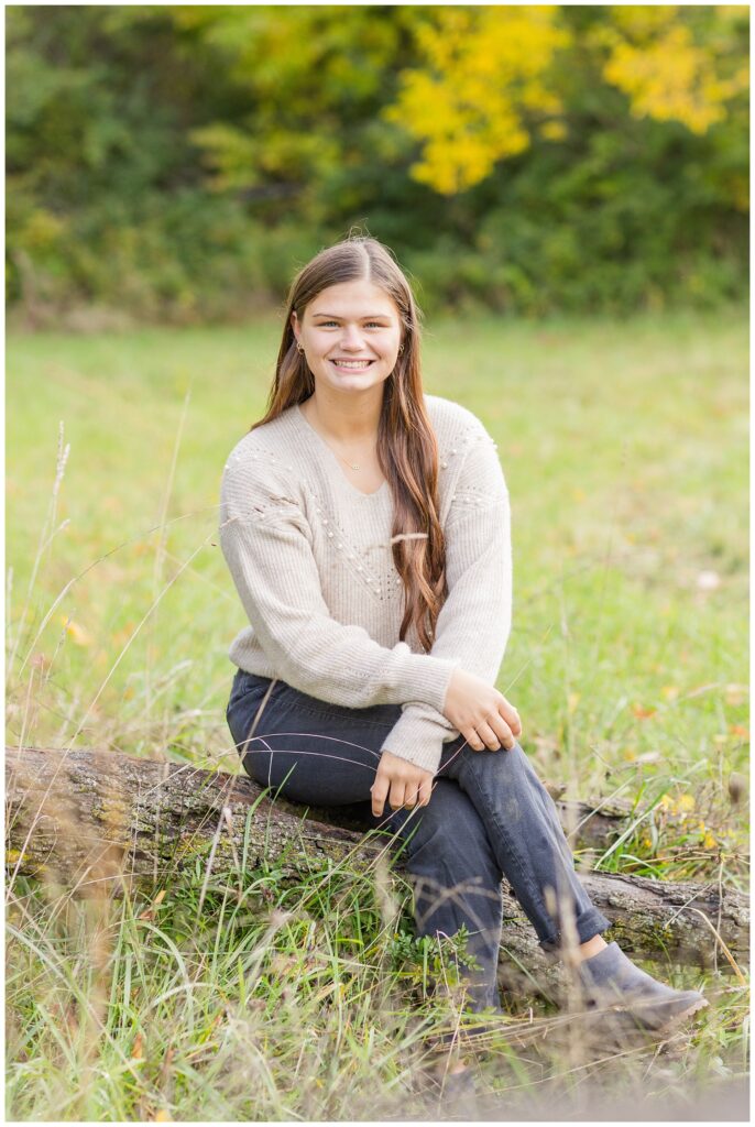 senior girl sitting on a log for session in Sandusky