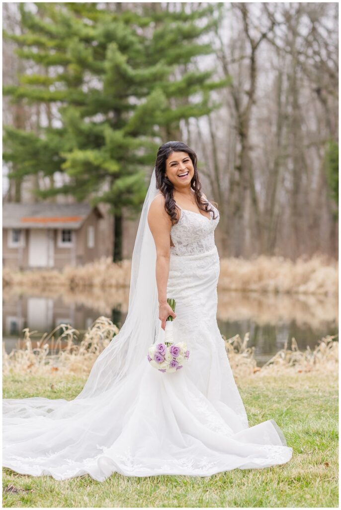 bride holding her lavender and ivory bouquet next to a pond at Bradner Reserve