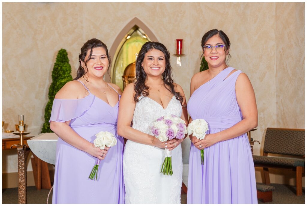 bride posing with two bridesmaids after Fremont, Ohio church ceremony