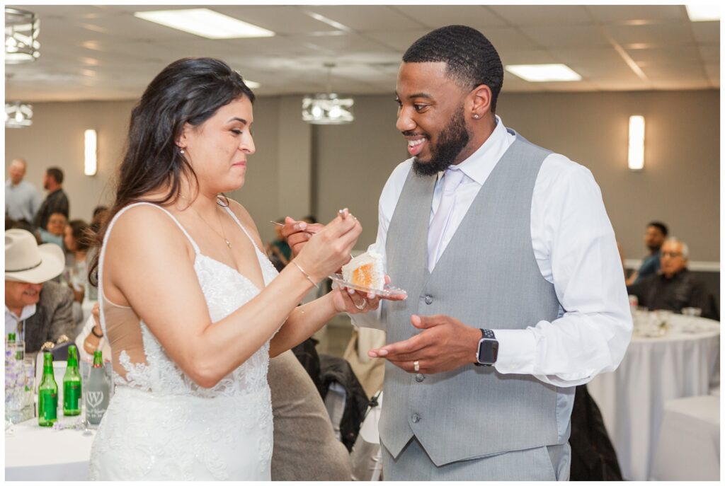 bride and groom sharing cake together at spring wedding reception